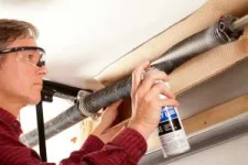 homme faisant l'entretien d'une porte de garage