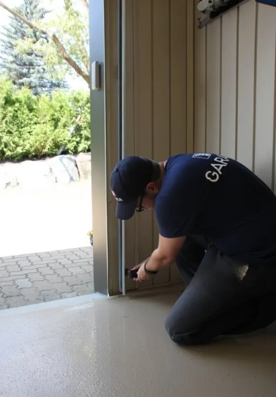Installateur en train d'installer les rails d'une porte de garage