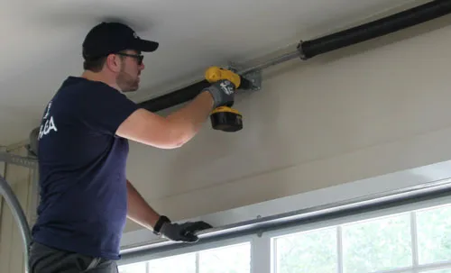 Expert en portes de garage qui installe une porte de garage