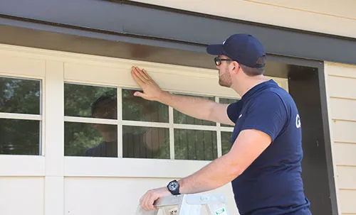 Expert en portes de garage qui installe les fenêtres d'une porte de garage